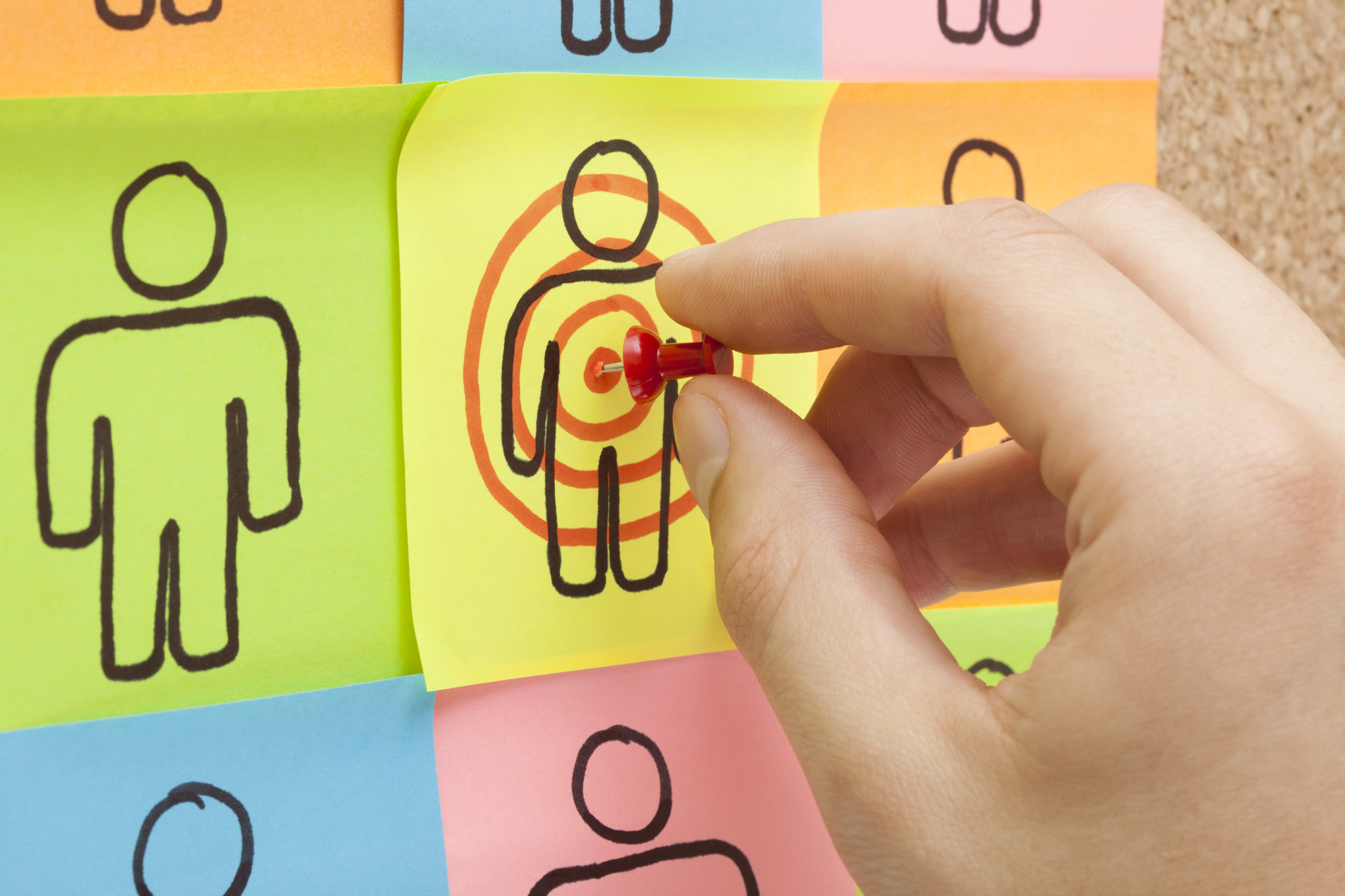 Reaching the target market finding the target market - photo of pinning a target on post-it note character